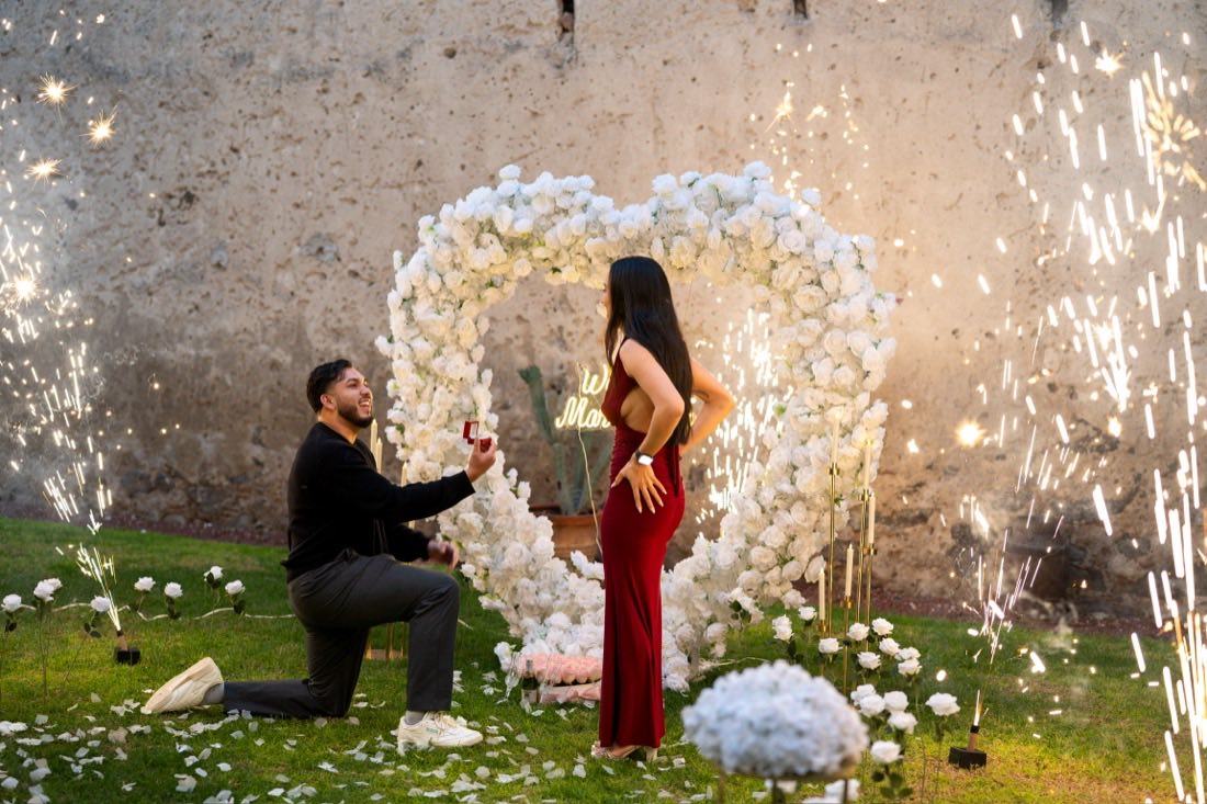 Pedida de matrimonio con corazón de rosas blancas y fuegos artificiales