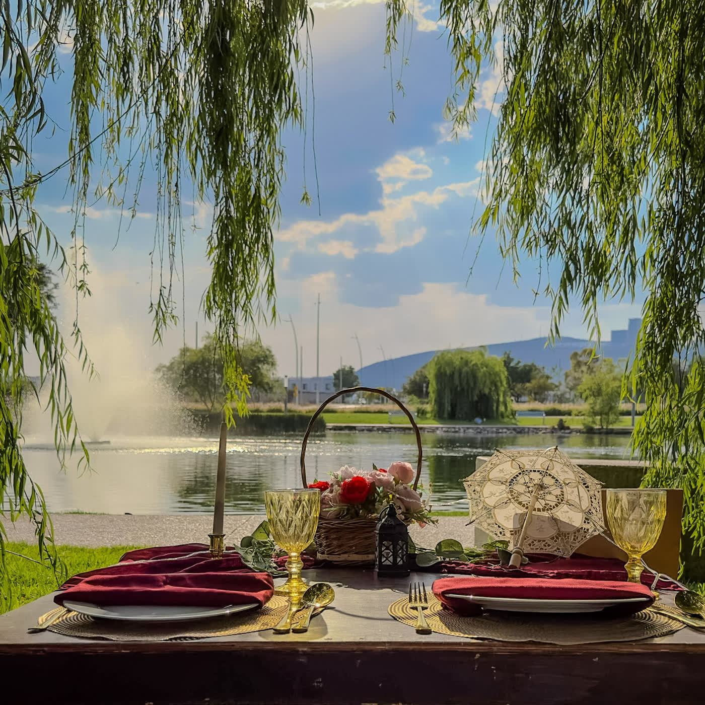 Teepee blanco junto al lago bajo sauces para cita romántica